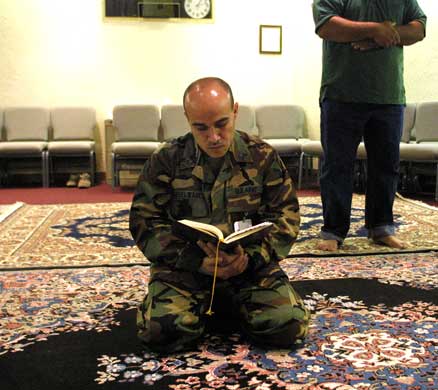 An Army sergeant reads from a prayer book before a service