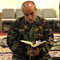 an Army sergeant reads from a prayer book